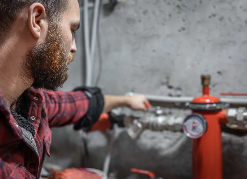 Technicien certifié BATEA effectuant la vérification annuelle d'un extincteur dans un local professionnel